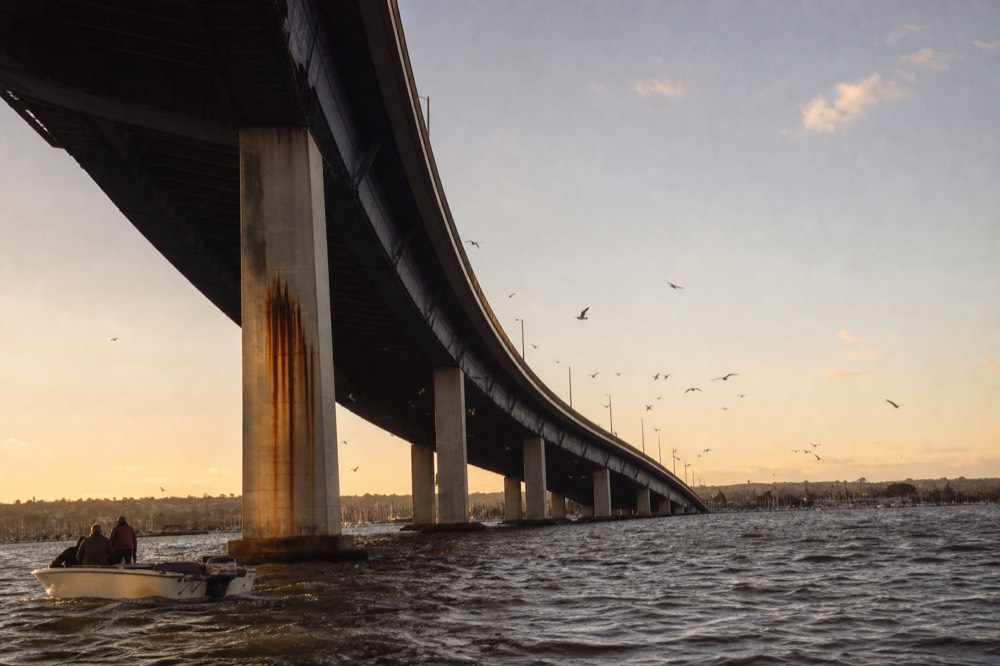 The Coronado Bridge spanning the bay in warm evening light seen from the water, no text, no logos, no people