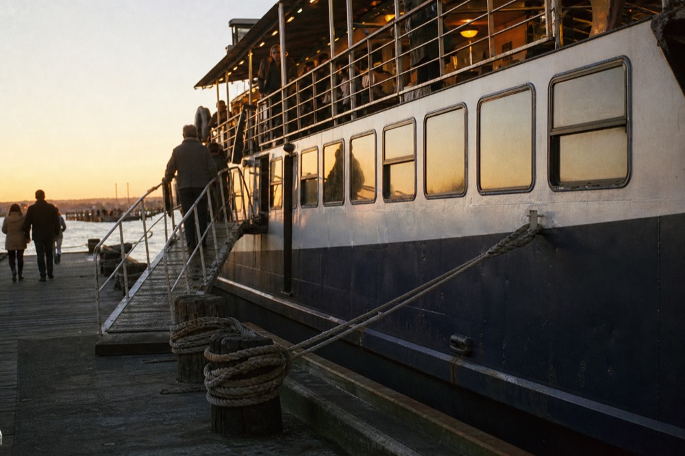 A dinner cruise vessel docked at a San Diego Bay pier in the early evening, no text, no logos, no people