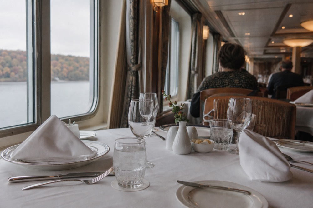 A set dinner table on a cruise ship with place settings and glassware, no text, no logos, no people