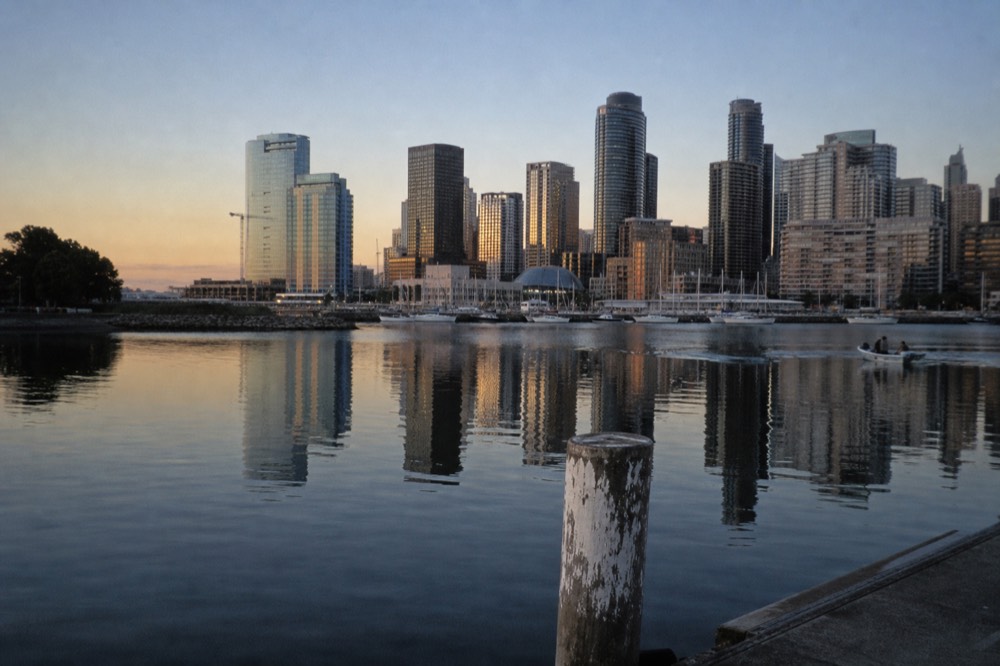 A calm San Diego Bay at dusk with the downtown skyline reflected in the water, no text, no logos, no people