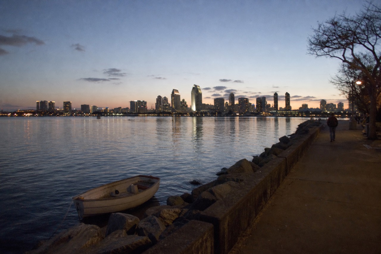 San Diego Bay at dusk with city lights reflecting on the water, no text, no logos, no people.
