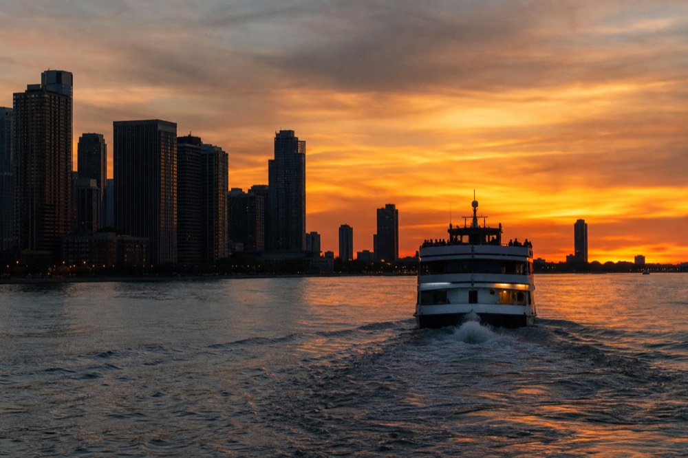 Dinner cruise boat on San Diego Bay at sunset with the skyline behind, no text, no logos, no people