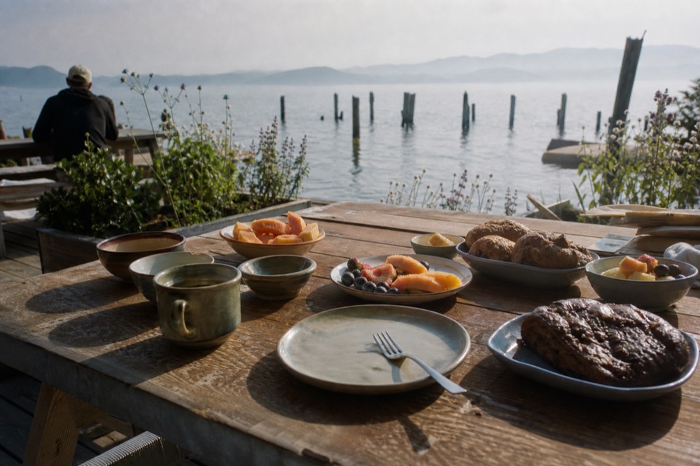 Brunch buffet spread with pastries and fruit on a waterside table, no text, no logos, no people