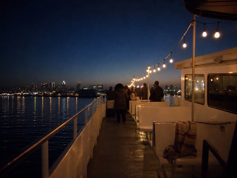 Boat deck strung with lights on San Diego Bay on a clear winter evening
