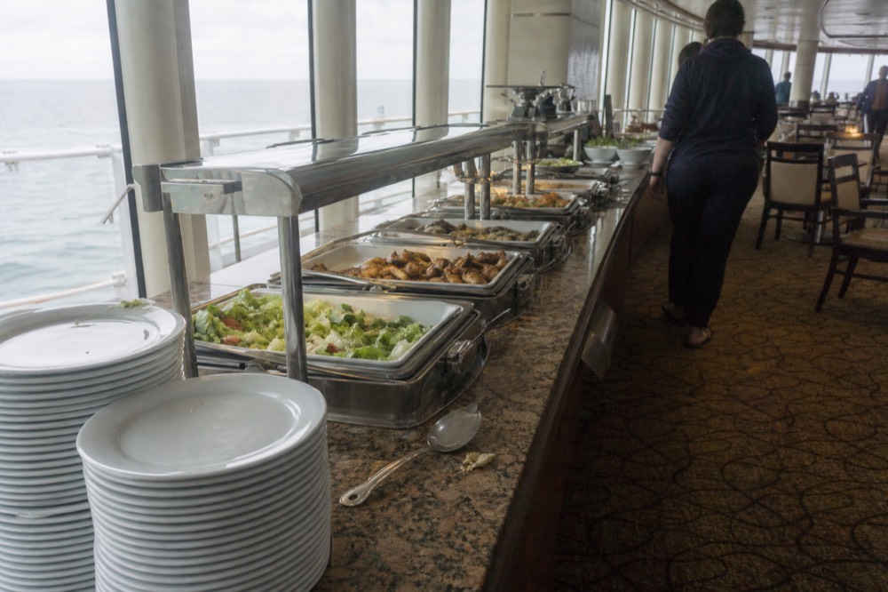 A buffet station with fresh salads and entrees arranged along a cruise ship dining room counter, no text, no logos, no people