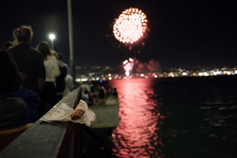 A dinner table set beside a window with the San Diego skyline across the bay, no text, no logos, no people