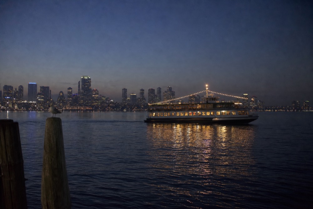 Passengers boarding a dinner cruise at a San Diego Bay pier in early evening light, no text, no logos, no people