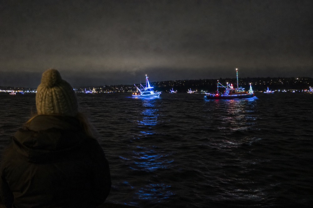 Champagne glasses raised on the deck of a cruise boat with San Diego city lights in the background, no text, no logos, no people