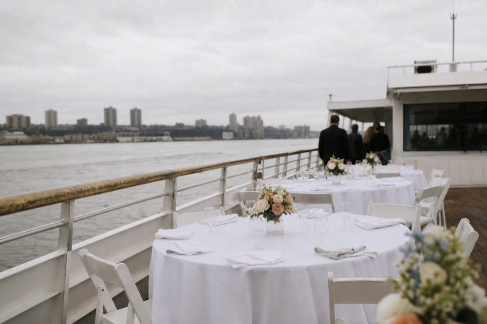 A private dining deck on a San Diego harbor cruise set with linen tablecloths and centerpieces, no text, no logos, no people