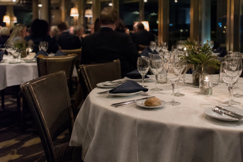 An indoor dining room on a San Diego dinner cruise with tables set for a large group, no text, no logos, no people