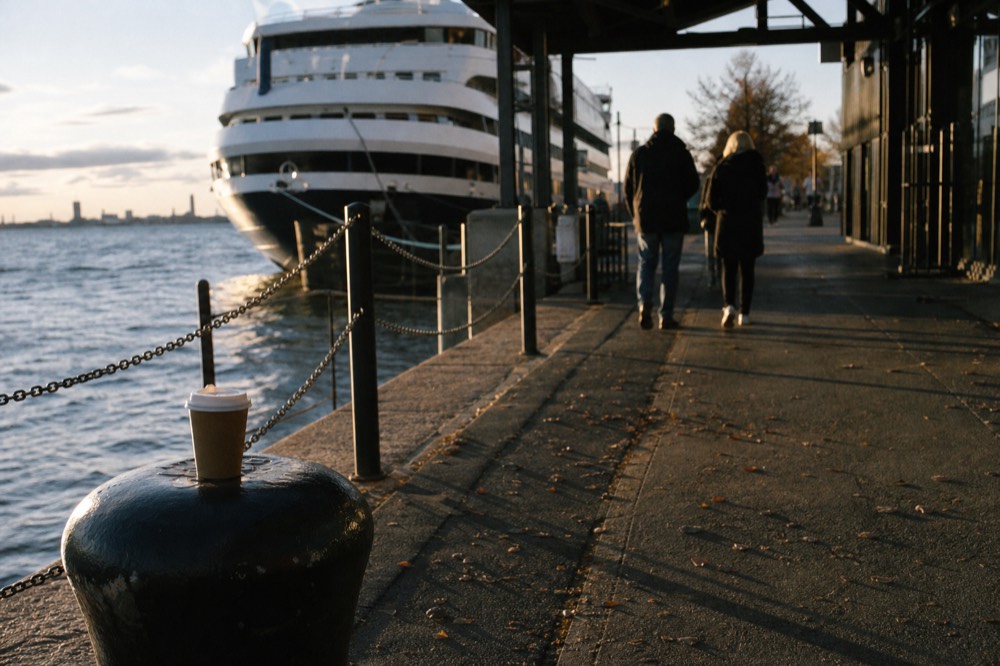 A pier entrance on the San Diego waterfront at golden hour with a cruise vessel waiting, no text, no logos, no people