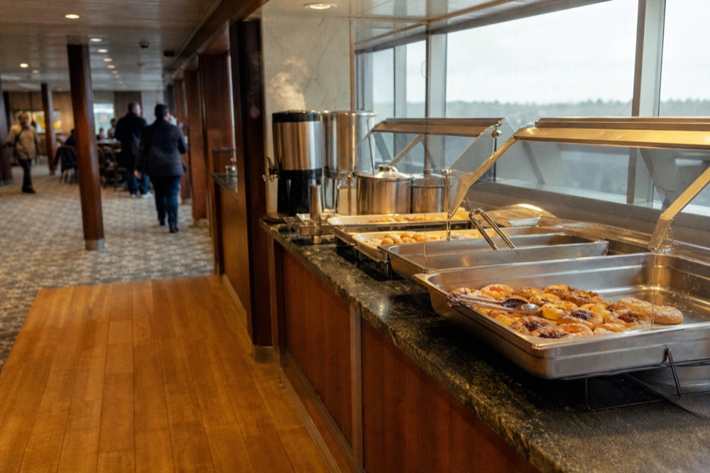 Breakfast and lunch buffet stations arranged along a cruise ship dining cabin, no text, no logos, no people