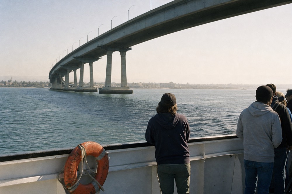 A tour boat passing under the Coronado Bridge on San Diego Bay, no text, no logos, no people