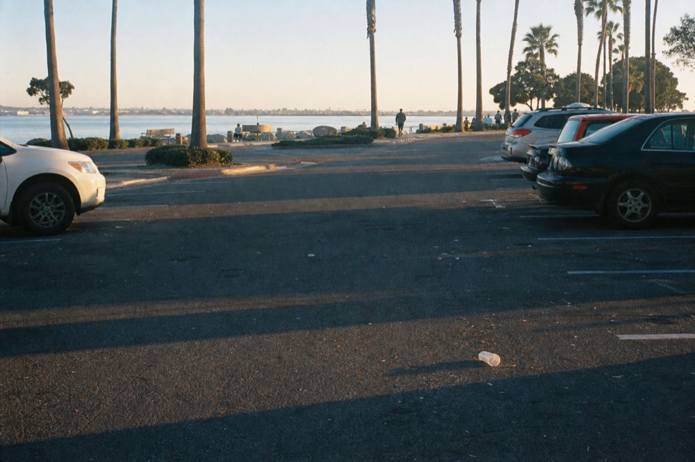 A public parking lot and waterfront promenade near the San Diego Embarcadero piers, no text, no logos, no people