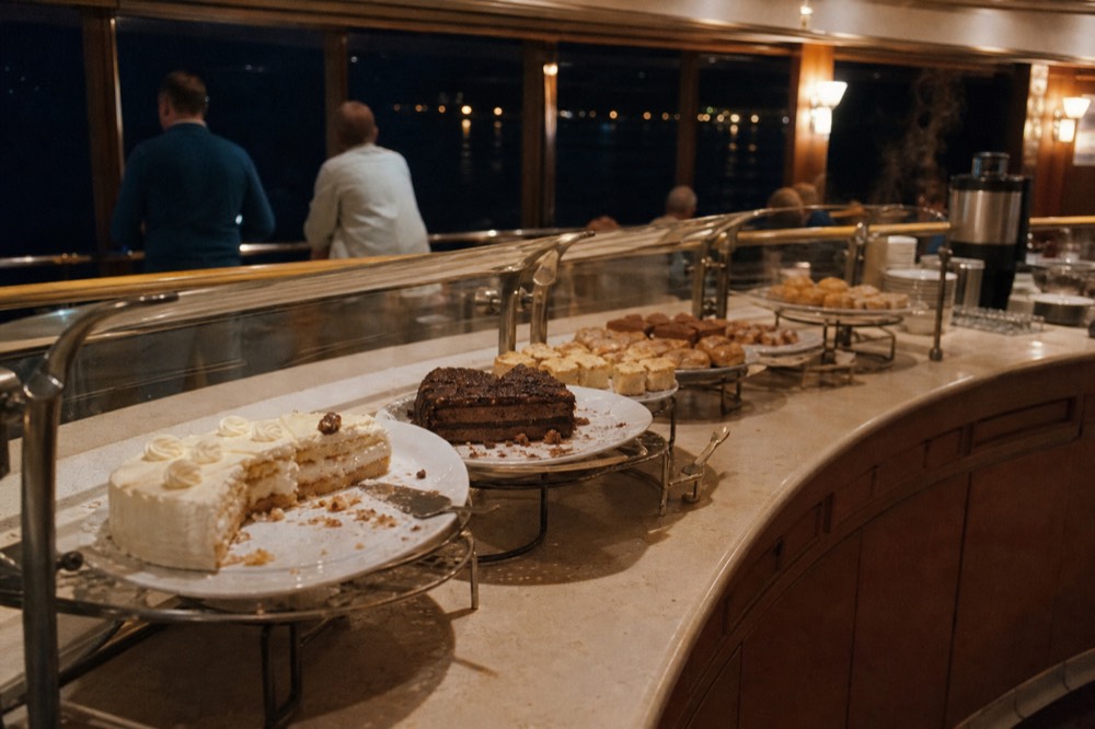 Dessert station with cake slices and pastries arranged on a cruise buffet, no text, no logos, no people
