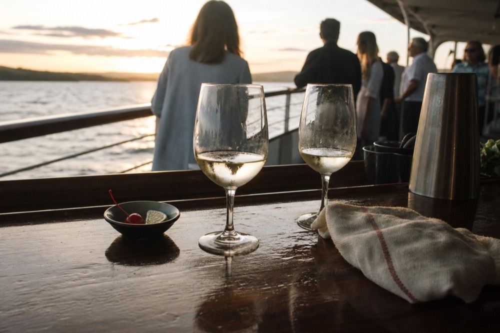 Bar counter with wine glasses and cocktail garnishes aboard a dinner cruise, no text, no logos, no people