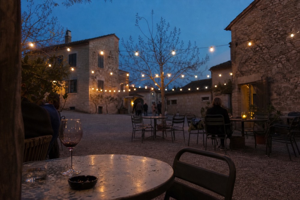 Seaport Village courtyard with outdoor seating and string lights in the evening, no text, no logos, no people