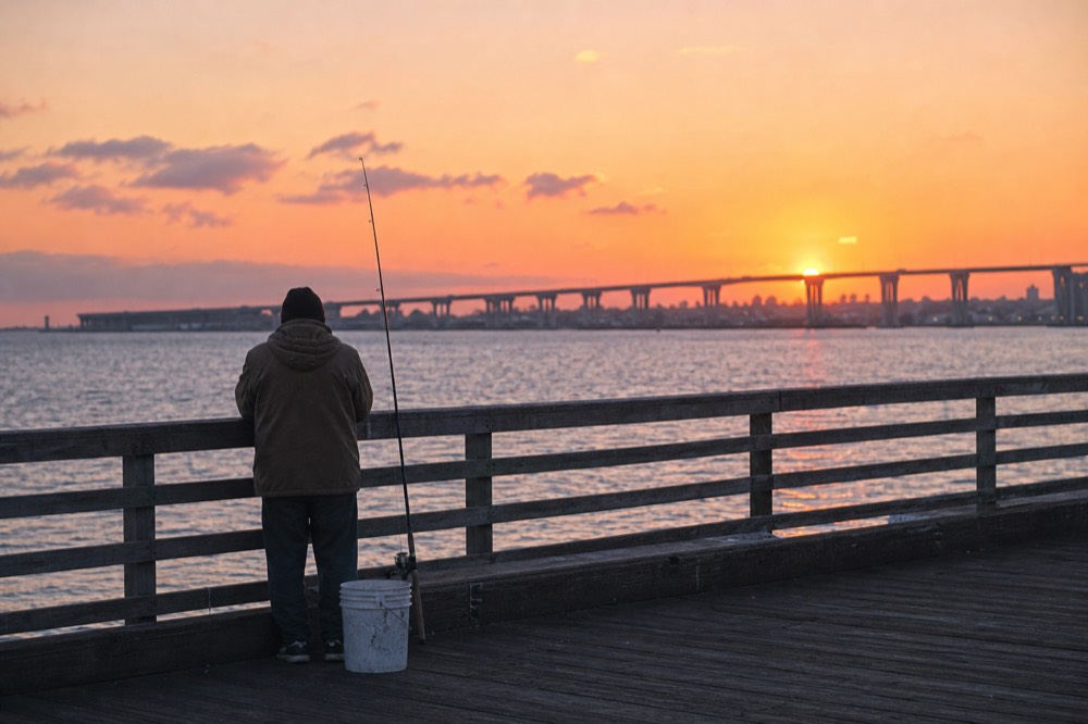 Sunset colors over San Diego Bay seen from a waterfront boardwalk, no text, no logos, no people
