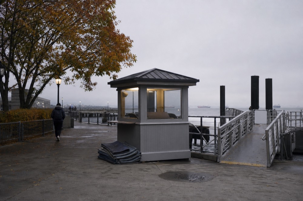 A ticket booth and boarding ramp at a San Diego Bay pier in the early evening, no text, no logos, no people