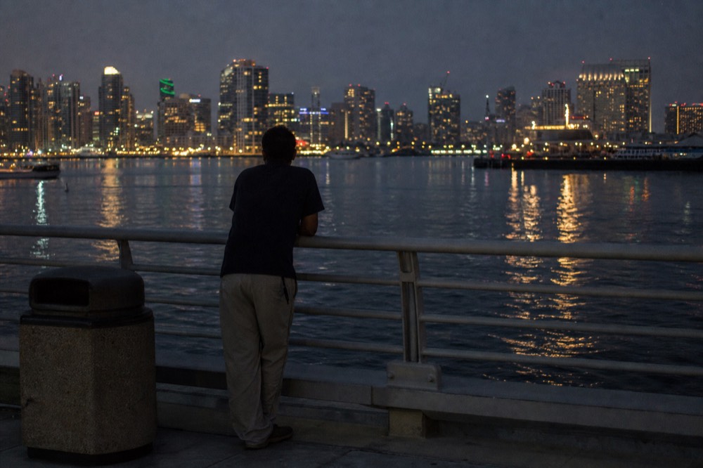 City lights beginning to appear along the San Diego waterfront as darkness settles over the bay, no text, no logos, no people